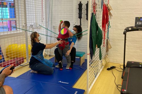 Boy in the spider cage in physiotherapy, with 2 physiotherapists at CPotential