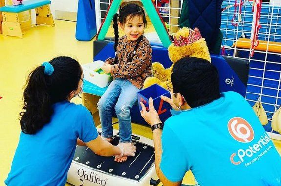 girl sitting with feet on galileo vibration plate in physiotherapy at CPotential